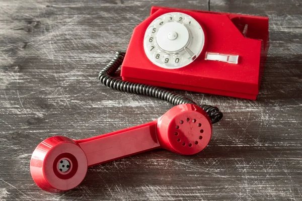 木制底座上有旋转拨号盘的红色老式电话 — 图库照片
