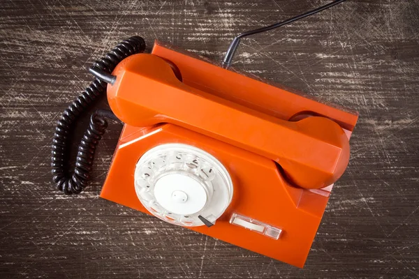 有旋转拨号盘的旧橙色复古电话 木制背景图 — 图库照片