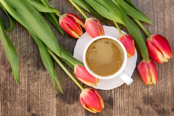 Egy Rakás Vörös Tulipán Fehér Csésze Kávé Barna Asztalon — Stock Fotó