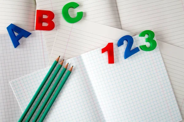 Bunte Zahlen Und Buchstaben Auf Schulheften Mit Vier Bleistiften — Stockfoto