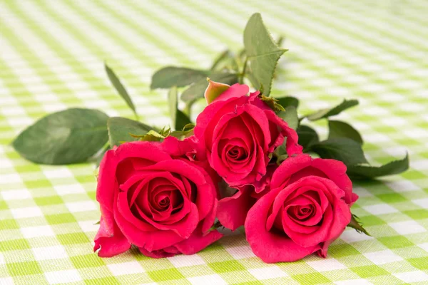 Buquê Rosas Vermelhas Mesa Com Toalha Mesa Quadriculada — Fotografia de Stock