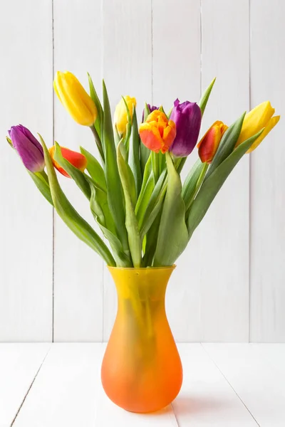 在白色木制背景的花瓶里有一束五彩缤纷的郁金香 — 图库照片