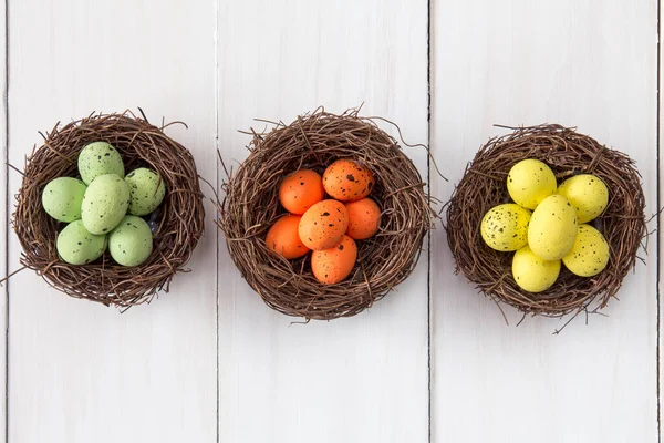 Três Ninhos Com Ovos Pintados Fundo Madeira Vista Superior — Fotografia de Stock