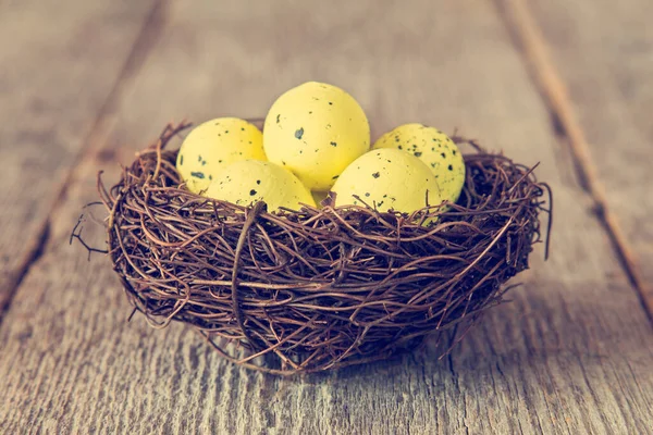 Διακοσμητικά Κίτρινα Αυγά Στη Φωλιά Ξύλινο Φόντο — Φωτογραφία Αρχείου