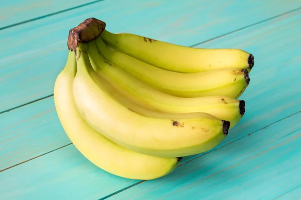 Banany Niebieskim Pomalowanym Drewnianym Tle — Zdjęcie stockowe