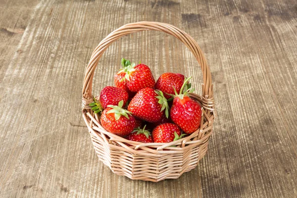 木制背景的柳条篮新鲜草莓 — 图库照片