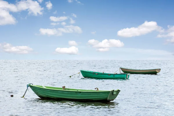 Three wooden boats floating out to sea