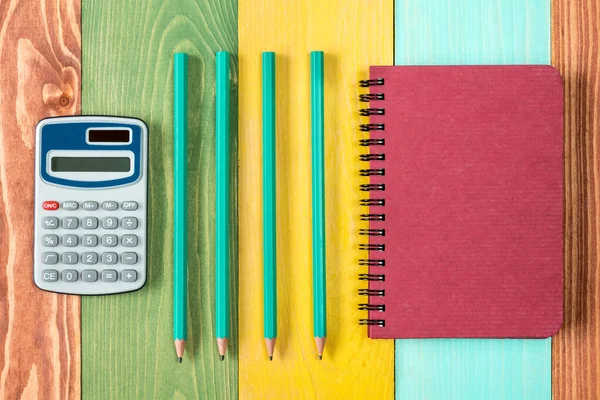 Notatnik Kalkulator Cztery Ołówki Kolorowym Tle — Zdjęcie stockowe