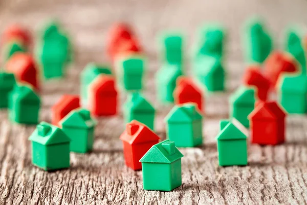 Rote Und Grüne Plastikspielzeughäuser Auf Einem Hölzernen Hintergrund Immobilienkonzept — Stockfoto