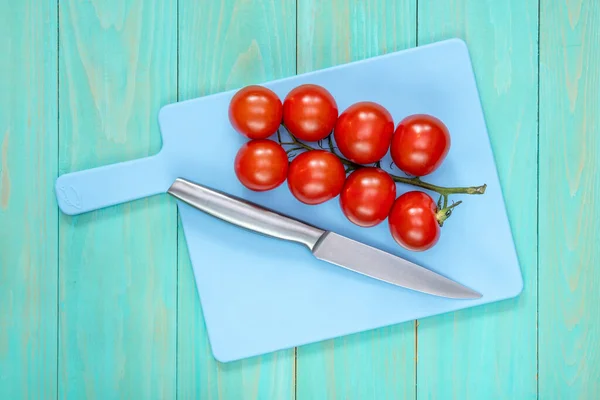 Ramo Tomates Faca Uma Tábua Corte Azul — Fotografia de Stock