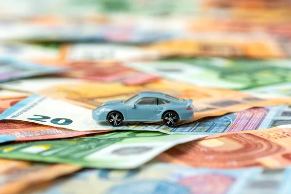 Car model on money background. Saving money for a car.