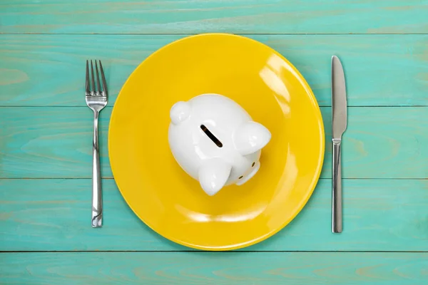 节约消费者的概念 用叉子和刀叉在黄盘上的猪排 — 图库照片