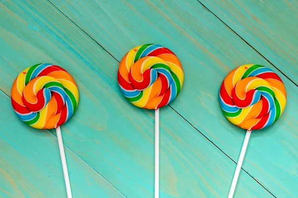 Drei Bunte Lolly Pops Auf Blauem Holzhintergrund — Stockfoto