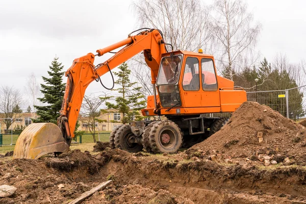 Orange Grävmaskin Gräver Ett Dike För Stadens Kommunikationer — Stockfoto