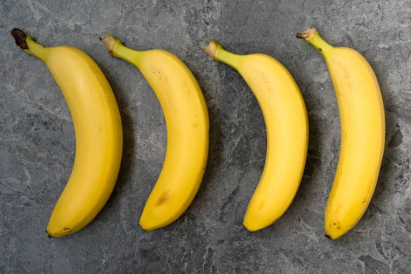 Four Bananas Placed Dark Stone Background — Stock Photo, Image