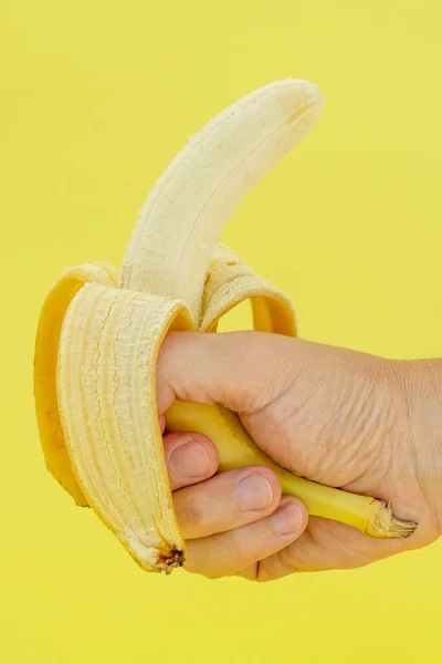 Menselijke Hand Met Banaan Gele Achtergrond Voedingsconcept — Stockfoto