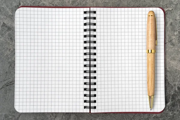石の背景にペンで空白のメモ帳 スペースのコピー — ストック写真