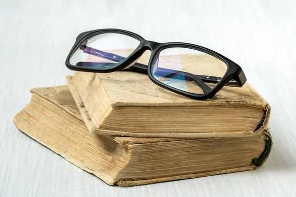 Brillen Stapels Boeken Geplaatst Witte Houten Ondergrond — Stockfoto