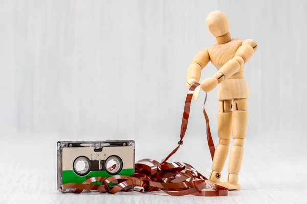 Wooden Man Pulling Out Tape Old Audio Cassette Vintage Outdated — Stock Photo, Image