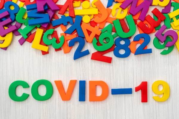 Covid Bunten Buchstaben Auf Einem Hölzernen Hintergrund — Stockfoto