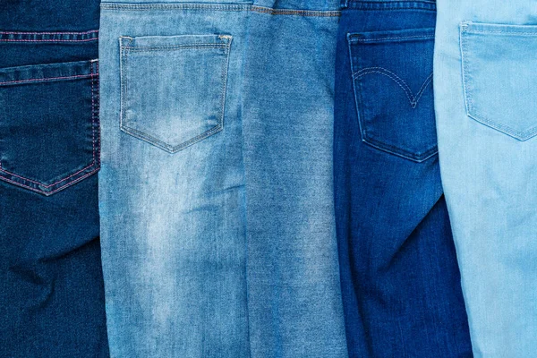 Sıraya Dizilmiş Mavi Tonlarda Değişik Kot Pantolonların Desenli Arka Planı — Stok fotoğraf