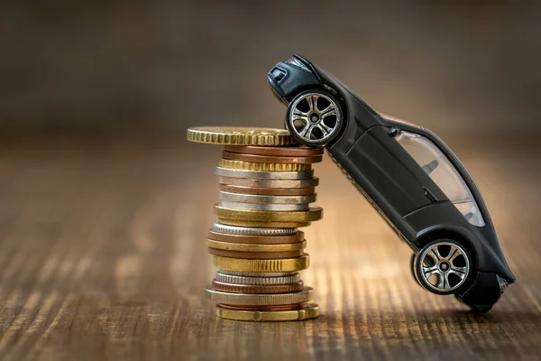 Schwarzes Auto Über Einer Menge Gestapelter Münzen Konzept Für Autoversicherung — Stockfoto
