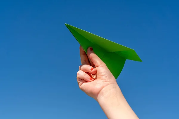 澄んだ青空に子供の手に紙飛行機 — ストック写真