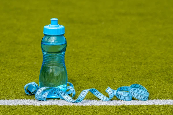 Eine Flasche Wasser Und Maßband Auf Dem Grünen Fußballplatz — Stockfoto