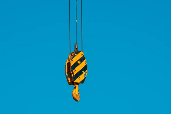 青空の背景に負荷を持ち上げるためのリフティングギアに大きな黄色のクレーンフック 施工概念 — ストック写真
