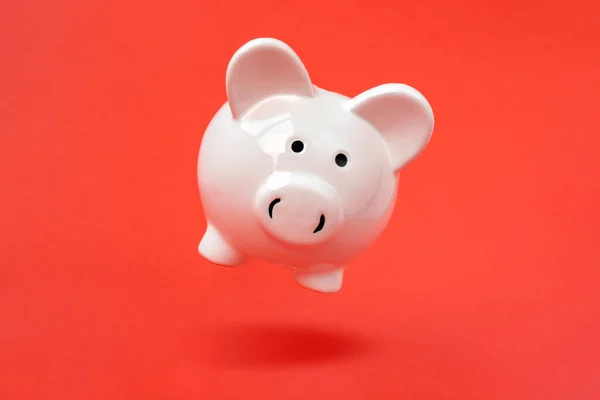 Secure Savings Piggy Bank Levitating Red Background Copy Space — Stock Photo, Image