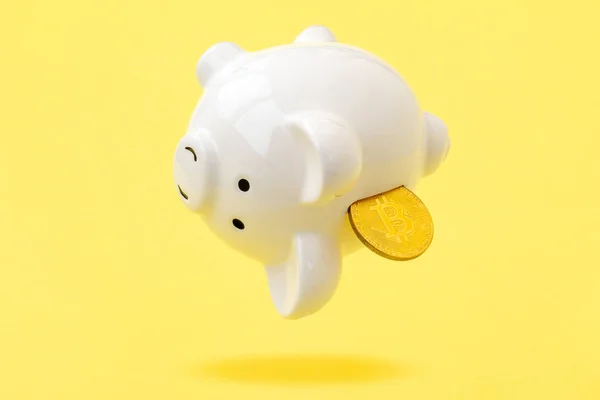 带有比特币的小猪银行掉在了黄色的背景上 比特币投资的风险和危险 — 图库照片