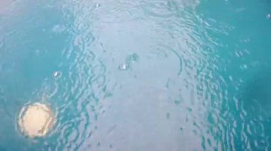 Bir yüzme havuzu üzerinde açılış ağır yağmur damlaları