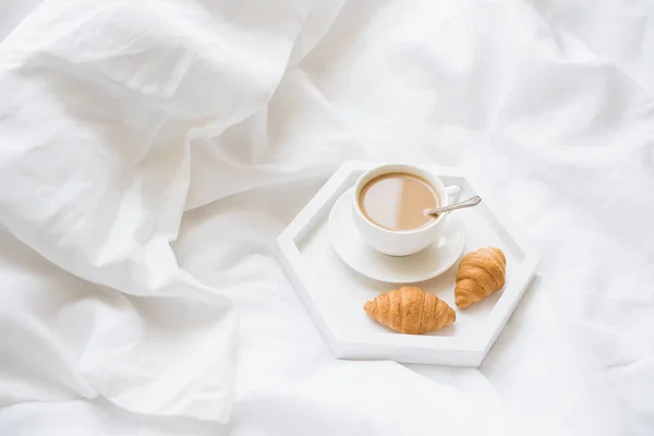 Frühmorgens Frühstück im Bett, Kaffee und Croissant auf dem Tablett — Stockfoto