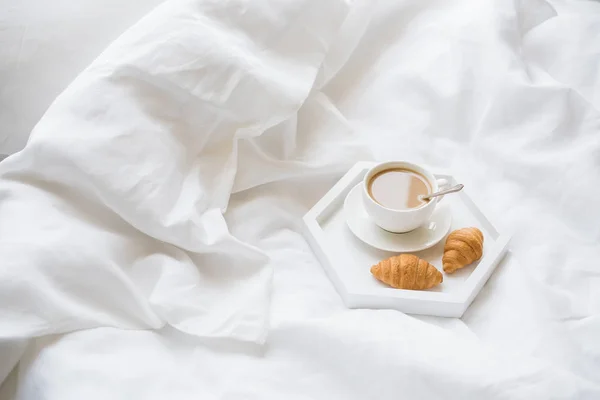Early morning breakfast in bed, coffee and croissant on the tray — Stock Photo, Image