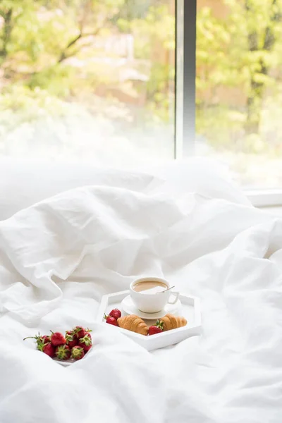 Desayuno por la mañana temprano en la cama, café y croissant con fresa — Foto de Stock