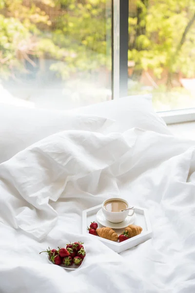 Desayuno por la mañana temprano en la cama, café y croissant con fresa — Foto de Stock