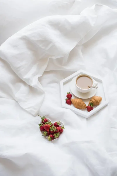 Early morning breakfast in bed, coffee and croissant with strawb — Stock Photo, Image