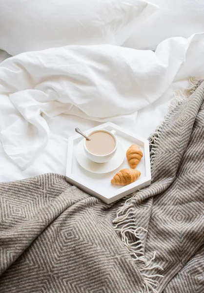 Acogedor desayuno en la cama, taza de café y croissants en blanco y — Foto de Stock