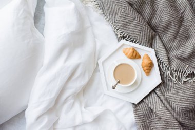 Rahat odaya yatak, fincan kahve ve kruvasan beyaz ve