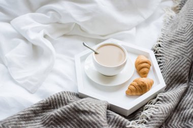 Rahat odaya yatak, fincan kahve ve kruvasan beyaz ve