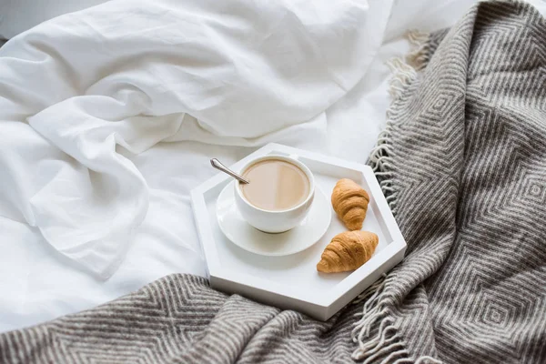 Acogedor desayuno en la cama, taza de café y croissants en blanco y — Foto de Stock