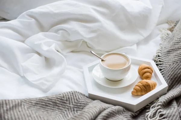 Gemütliches Frühstück im Bett, Tasse Kaffee und Croissants auf weiß und — Stockfoto