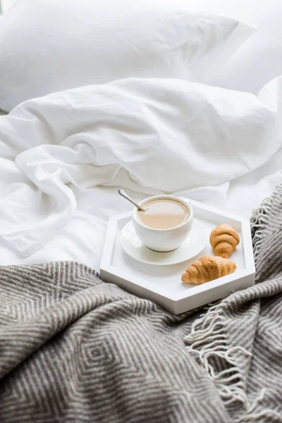 Acogedor desayuno en la cama, taza de café y croissants en blanco y — Foto de Stock