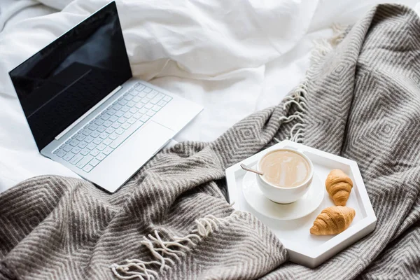 Cozy weekend at home, laptop and coffee in bed