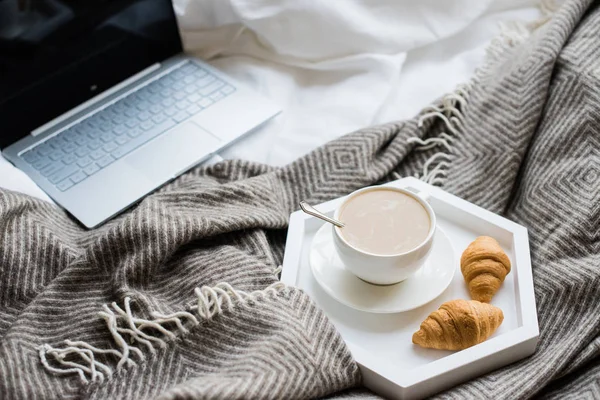 Уютные выходные дома, ноутбук и кофе в постели — стоковое фото