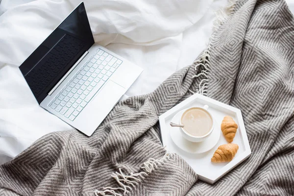 Cozy weekend at home, laptop and coffee in bed