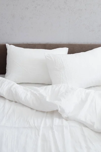 Cozy bed with crumpled white linen — Stock Photo, Image