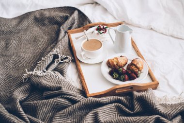 Beyaz ve bej yatak odasında yatakta romantik geleneksel kahvaltı