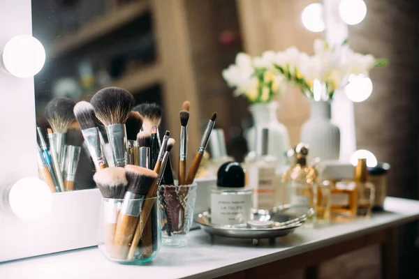 Perfumaria e cosméticos em uma mesa de vestir com um espelho — Fotografia de Stock