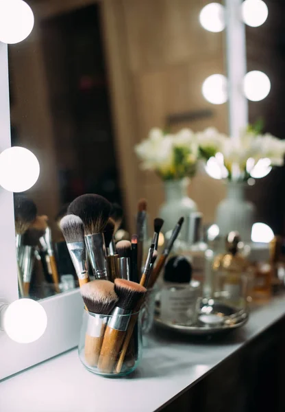 Perfumaria e cosméticos em uma mesa de vestir com um espelho — Fotografia de Stock